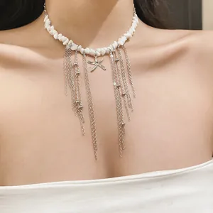Close-up of white stone bead necklace with starfish pendant and silver tassel chains