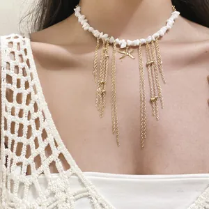 Detailed shot of a beach-style white stone beaded necklace with golden starfish tassels