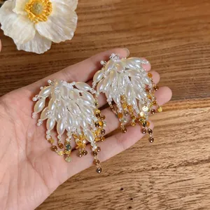 Handheld elegant pearl tassel stud earrings with dangling gold chain fringe and metallic sequins