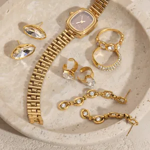 Detailed view of golden zircon jewelry collection featuring rings and ear cuffs on stone tray