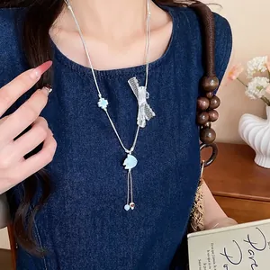 Exquisite ceramic fish necklace with lace bow and blue clover for fresh vacation look.