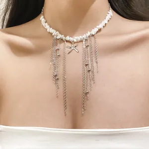 Detail of white beaded necklace with silver starfish pendant and tassel chains