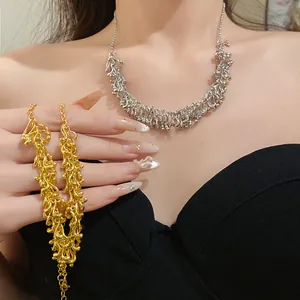 Detailed view of silver and gold irregular geometric fringe necklaces on a model.