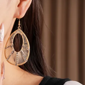 Élégantes boucles d'oreilles dorées en forme de larme avec strass sur mannequin