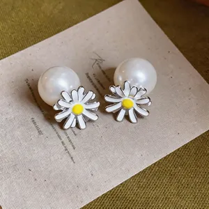 Elegant fresh daisy enamel earrings with large white pearls on artistic paper card
