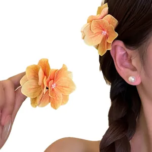 Elegant orange floral hair clip for island vacation and beach photography.