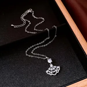 Elegant zircon fan-shaped pendant necklace displayed on a luxury black jewelry tray.
