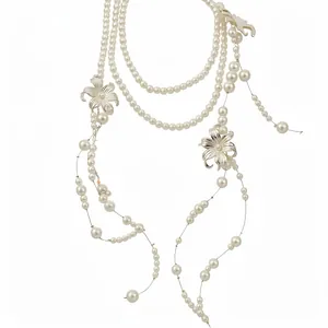 Elegant multi-layer pearl necklace with silver floral accents and long tassels.