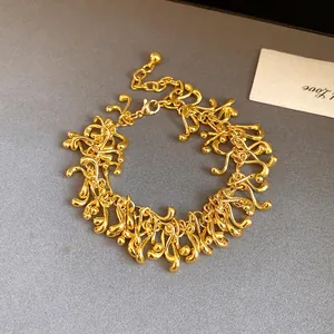 Detailed shot of an irregular geometric gold tassel bracelet with vintage style