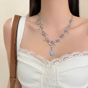Detailed view of elegant blue floral necklace featuring clear crystals and water-drop pendant