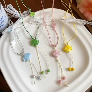 Handmade ceramic fish pendants with lace bow accents for a sweet vacation look.
