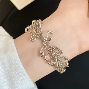 Detailed close-up of an elegant irregular geometric silver tassel bracelet on a wrist