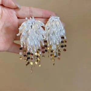 Detailed close-up of elegant pearl fringe earrings featuring shimmering gold sequins