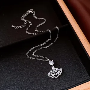 Exquisite detail shot of a silver fan-shaped zircon pendant necklace on black display