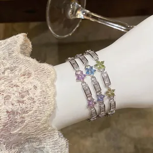 Elegant metal bracelets with colorful zircon flowers on wrist for a luxurious look