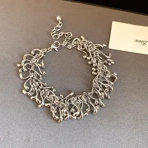Close-up of vintage silver irregular geometric tassel bracelet with fluid metal design