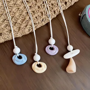 Close-up detail of colorful summer dopamine pleated resin pendants on white cords