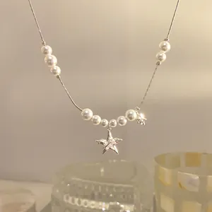 Dettaglio dell'elegante collana con pendente a stella, zirconi e perle bianche