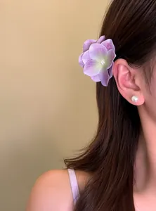 Close-up detail of a realistic purple hydrangea flower hair clip on long brown hair