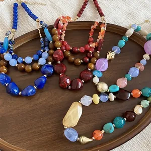Colliers ethniques faits à la main en perles de résine acrylique sur un plateau en bois