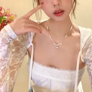 Primo piano di un'elegante collana di perle con pendente a stella in zircone su una modella.
