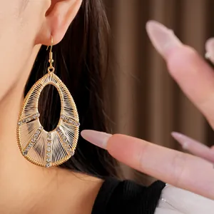 Gros plan d'élégantes boucles d'oreilles goutte tissées avec strass brillants sur un modèle