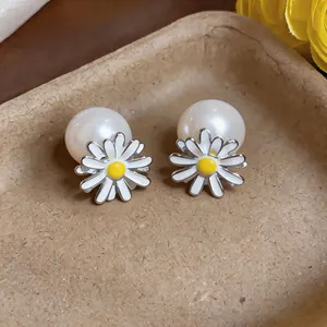 Detail view showing the delicate enamel daisy flower and large pearl earring stud