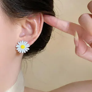Detailed close-up view of a white daisy flower stud earring worn on the ear lobe