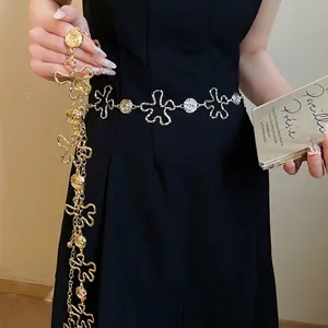 Ceinture chaîne en métal doré vintage avec fleurs évidées sur mannequin en robe noire