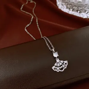 Macro view of an elegant silver fan-shaped pendant necklace set with brilliant zircon stones
