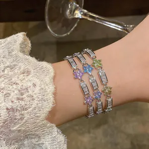 Close-up of elegant zirconia flower bracelets on a female wrist with lace sleeve detail