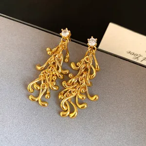 Close-up of gold irregular tassel earrings with sparkling crystal studs