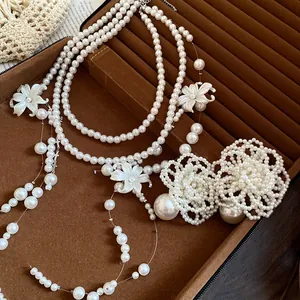 Close-up of elegant multi-layered pearl necklaces with delicate white shell flower accents.