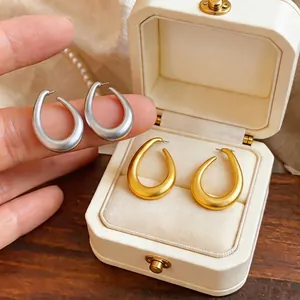 Matte finish minimalist oval hoop earrings in silver and gold colors for women.