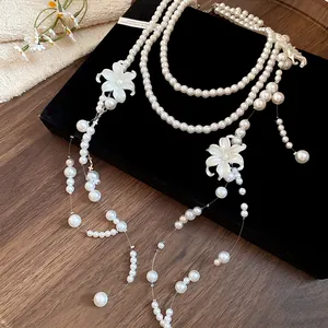 Close-up detail showing the intricate shell flowers on multilayer pearl necklace