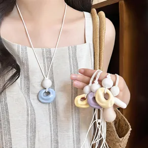 Close-up of resin wrinkled circle pendant necklaces in vibrant summer dopamine colors.