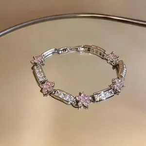 Macro detail of an elegant flower bracelet with pink zirconia and clear crystal accents.