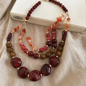 Vue détaillée de perles multicouches en résine acrylique aux tons rouge et ambre