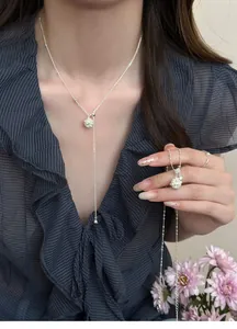 Close-up of elegant zircon flower cluster tassel Y-necklace shown on a female model