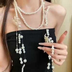 Detail shot of long multi-layer pearl necklace with shell flowers and tassels.