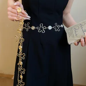 Détail d'une chaîne de taille en métal ajouré à fleurs vintage dorées et argentées