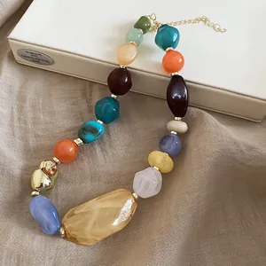 Gros plan de perles de résine colorées sur un collier de style ethnique et vintage