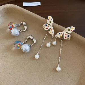 Eleganti orecchini a farfalla a pois colorati con nappe di perle e perline di vetro.