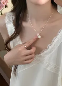 Close-up detail of a silver zircon flower cluster necklace worn by a female model.