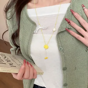 Detailed shot of yellow ceramic fish pendant necklace with cute white lace bow