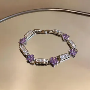 Detailed view of elegant silver bracelet featuring purple flower charms and clear zircon stones.