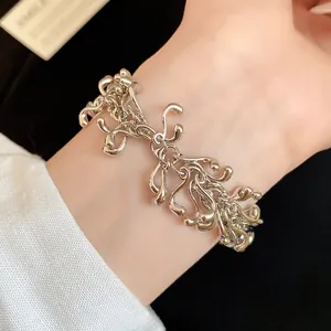 Close-up of a silver irregular geometric fluid molten metal bracelet on a wrist.