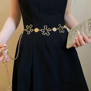 Détail élégant d'une chaîne de taille en métal doré vintage avec fleurs sur une robe noire