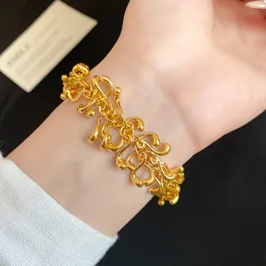 Detail of an irregular gold geometric tassel bracelet worn on wrist for luxury style.