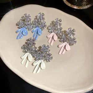 Detail view of exquisite sparkly zircon flower and enamel bow earrings in three colors